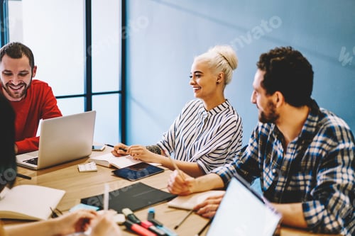 Preview: Group of cheerful colleagues discussing project in office