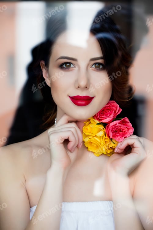 Preview: portrait of beautiful young woman standing near the window and looking at something