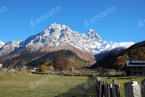 Preview: Picturesque view of village in high mountains under blue sky on sunny day