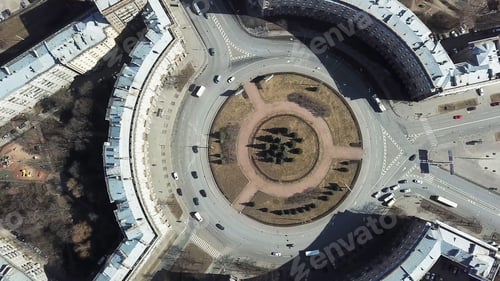 Preview: Top view of roundabout in city center. Roundabout with busy traffic of cars, surrounded by houses in