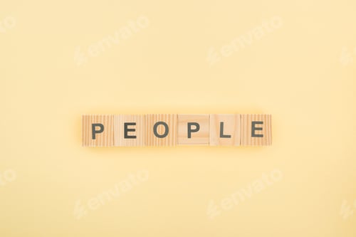 Preview: top view of people lettering made of wooden cubes on yellow background