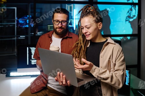 Preview: Young confident woman explaining online data to male colleague