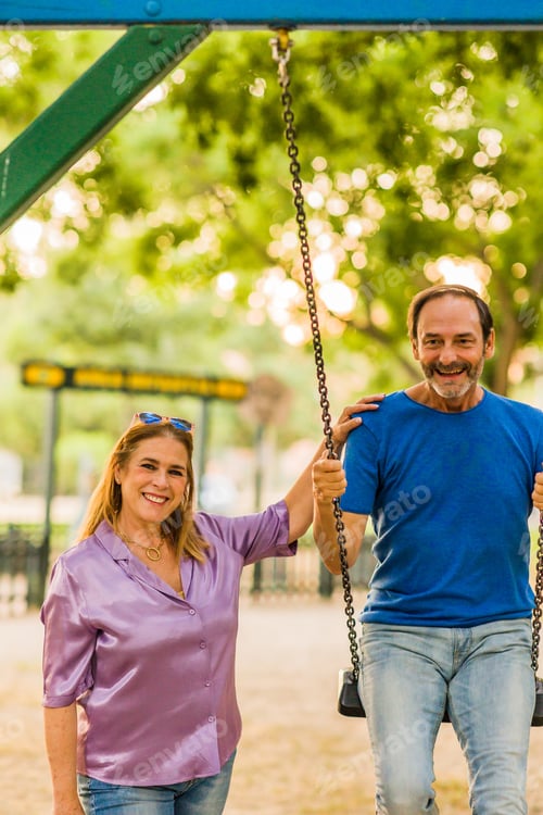 Preview: 50-59 years senior happiness relationship. Hispanic family enjoy life couple with a swing in a park