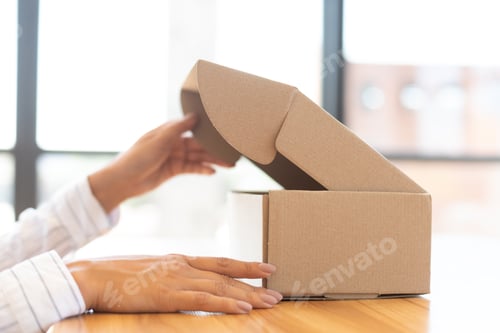 Preview: Lady opening box with new parcel, close-up