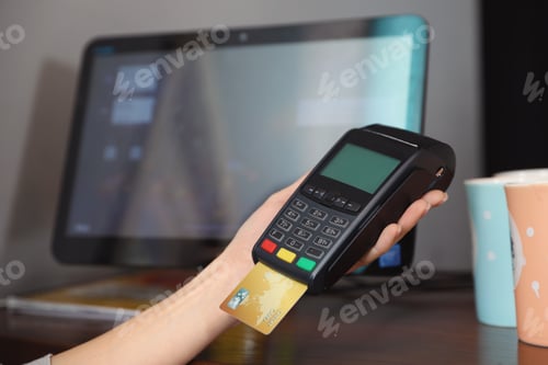 Preview: Woman using credit card machine for non cash payment in cafe, closeup. Space for text