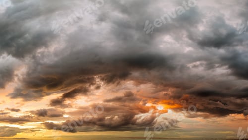 Preview: Bright sunset with setting sun behind vivid orange and yellow clouds
