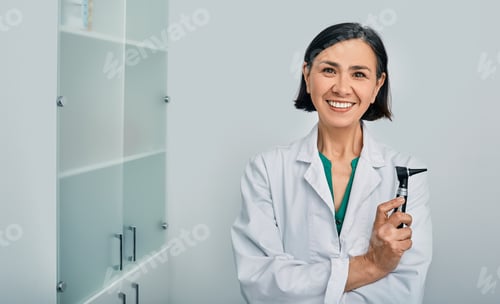 Preview: Woman audiologist with otoscope standing in medical clinic. Ear treatment and hear exam