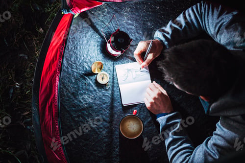Preview: Man camping in Estonia, drawing in his sketchbook at night