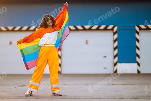 Preview: African lesbian woman holding LGBT rainbow flag. Concept of happiness, love for same-sex couples.