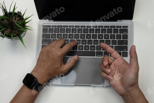 Preview: Male hands working on modern laptop. Office desktop on white background.