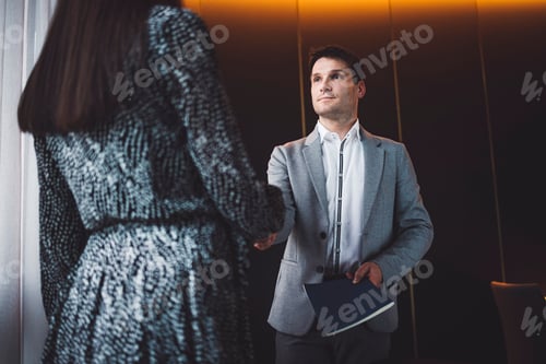 Preview: Two business people in business clothes are sitting in an office looking at a contract. One person i
