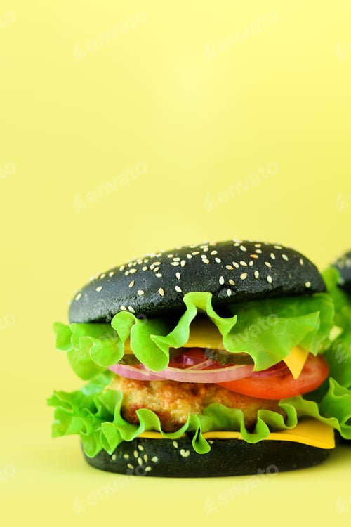 Preview: Fresh meat black burgers on yellow background. Take away meal. Fast food concept. Unhealthy diet