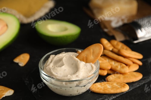 Preview: Delicious crackers and humus on black table, closeup