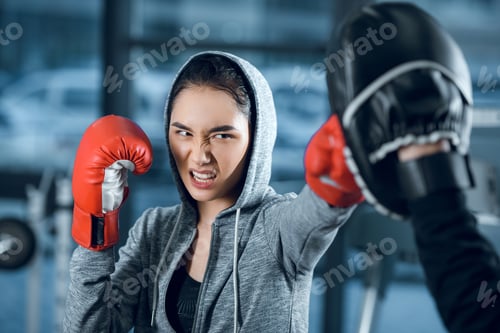 Preview: agressive young female boxer training at gym