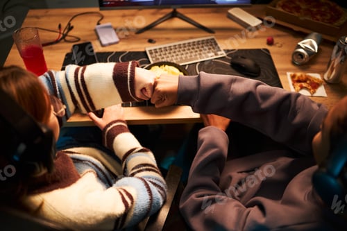 Preview: Teenage Friends Celebrating Victory While Gaming Together Indoors