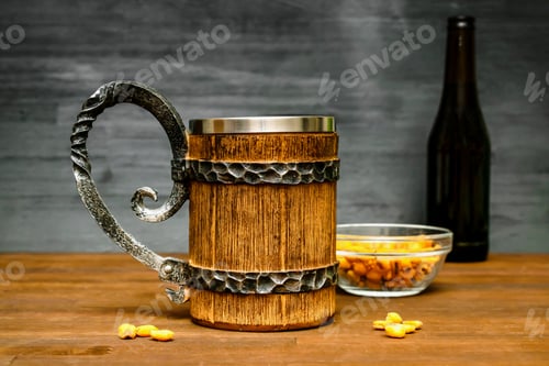 Preview: Big brown mug of beer,ale bottle and crispy snacks, pretzels, corn, nuts in bowl on wooden table