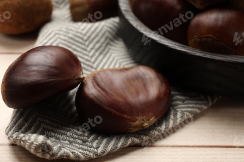 Preview: Sweet fresh edible chestnuts on light wooden table, closeup