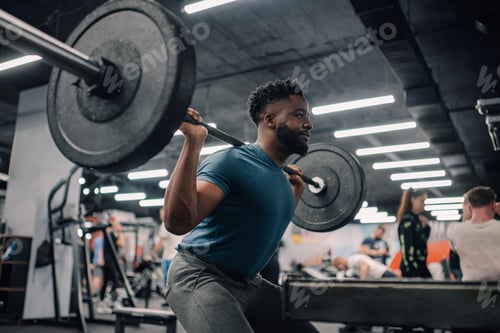 Preview: Determined bodybuilder lifting weights, performing squats in gym