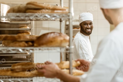 Preview: young bakers working together at baking manufacture