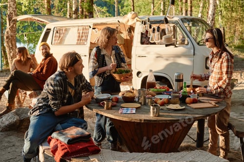 Preview: Friends arranging picnic on the nature