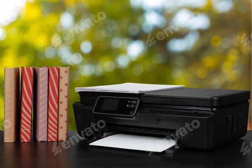 Preview: Stack of books and home printer against blurred background