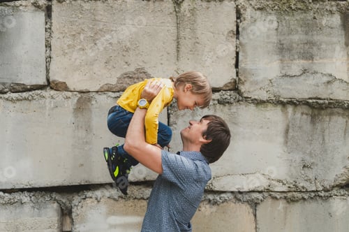 Preview: dad and kid son hug on arms. happy father playing child. authentic day-to-day fatherhood moments