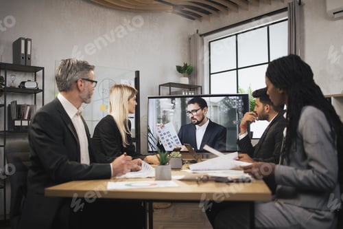 Preview: Confident bearded Caucasian man tells business program concept to his multinational colleagues