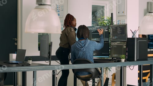 Preview: Diverse team of database admins analyzing source code and comparing data script