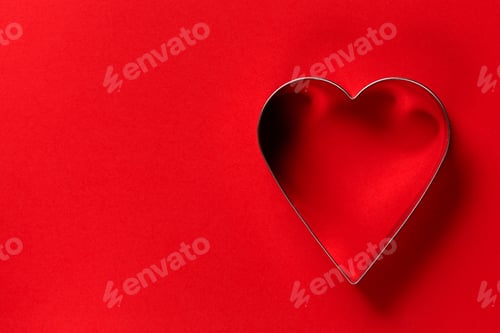 Preview: Saint Valentine day minimalistic greeting card, heart-shaped cookie cutters on red, flat lay