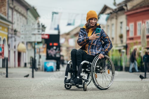 Preview: Woman with disability taking a selfie with her smartphone while out in the city