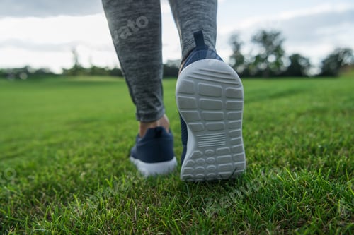 Preview: partial view of woman running on green lawn