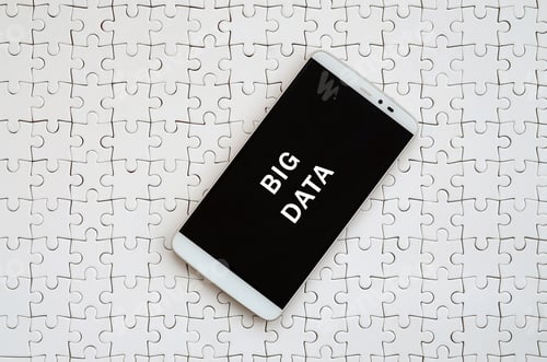 Preview: A modern big smartphone with a touch screen lies on a white jigsaw puzzle in an assembled state with