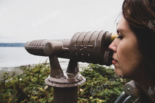 Preview: Tourist woman looking through scope at ocean view point