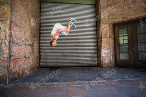 Preview: Extreme athlete doing a front flip in front of a building in the city