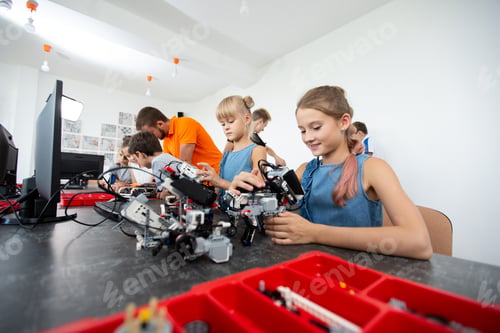 Preview: Cheerful kids working on the tech project at school