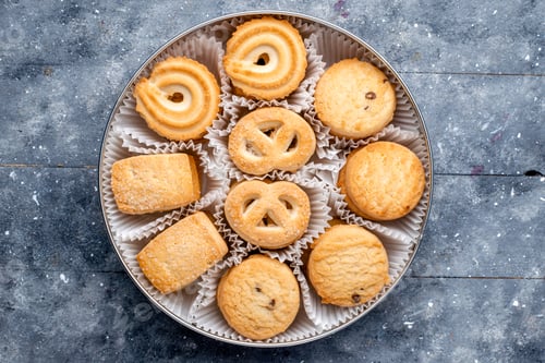 Preview: top view sweet delicious cookies different formed inside round package on the grey desk sugar sweet