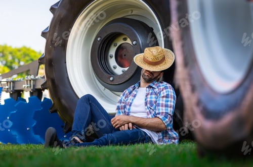 Preview: Farmer Relaxing Next to Agricultural Machinery