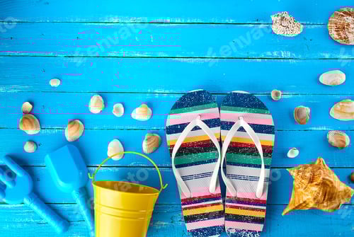 Preview: Pair of female beach slippers, a yellow baby bucket and scattered seashells