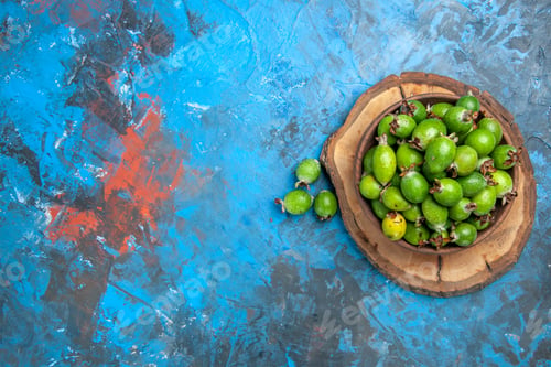 Preview: Above view of delicious vitamin bomb fresh feijoas in a brown pot on wooden tray on blue background