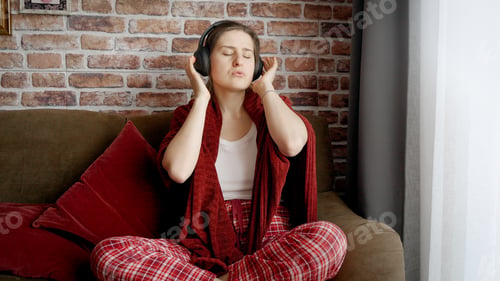 Preview: Portrait of active cheerful woman wearing headphones and dancing in house