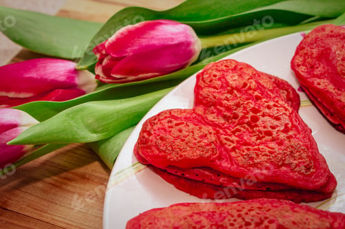 Preview: Red heart shaped pancakes made with love for valentines day and tulips on wooden background