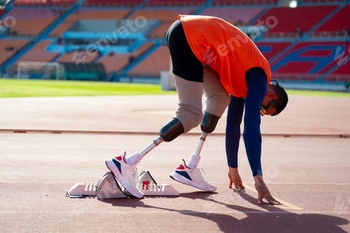 Preview: Asian para-athletes with prosthetic blades sprint on a running track at stadium.