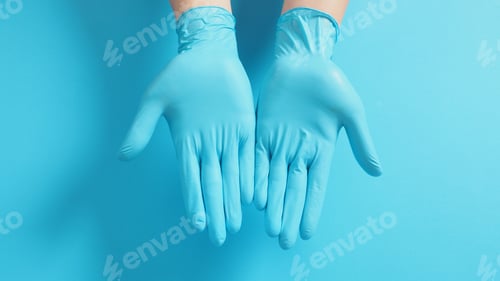 Preview: Two hand wear blue medical gloves on blue background.