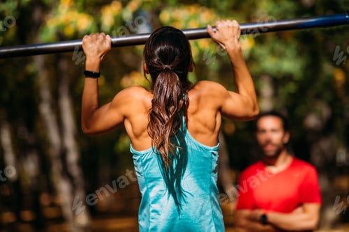 Preview: Woman doing pull-ups in the park