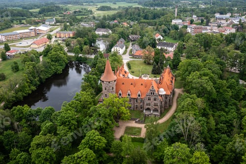 Preview: Cesvaine medieval castle in Latvia from above. Building of stones with a brown tiled roof.