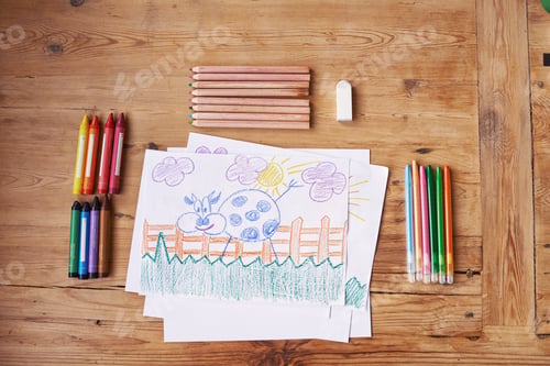 Preview: Shot of a drawing with painting supplies and pencils on a wooden table