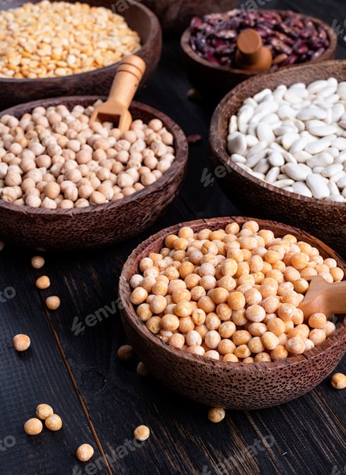 Preview: Various dried legumes in wooden bowls on white marble background