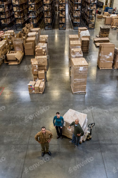 Preview: A group of three warehouse workers standing in the center of a distirbution warehouse.