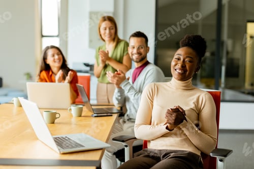 Preview: Cute Africam American woman with her young multiethnic startup team working in the modern office