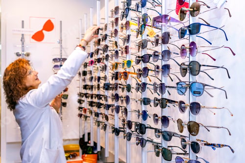 Preview: Row of glasses at an opticians. Eyeglasses shop. Stand with glasses in the store of optics.